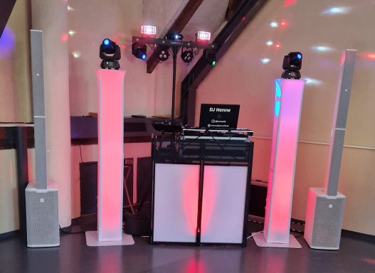DJs Anlage mit Lautsprechern, Lichtern und Mischpult in einem festlichen Raum.