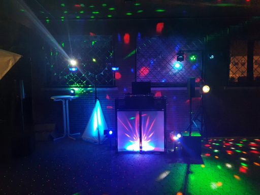 Bunte Lichter und eine DJ-Ausrüstung in einem festlichen Raum.